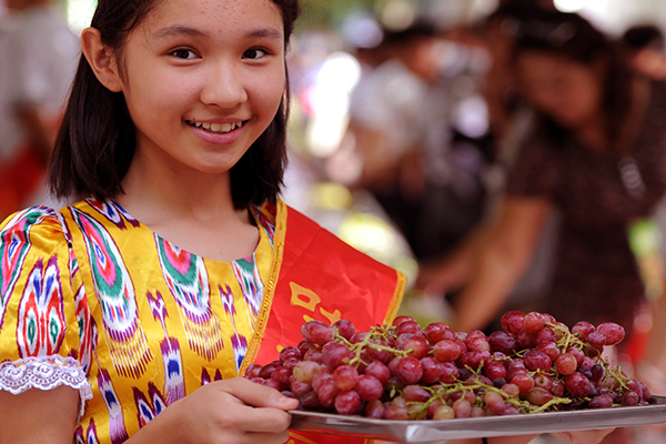 Uygur Girl Welcome Visitors to Turpan Grape Festival